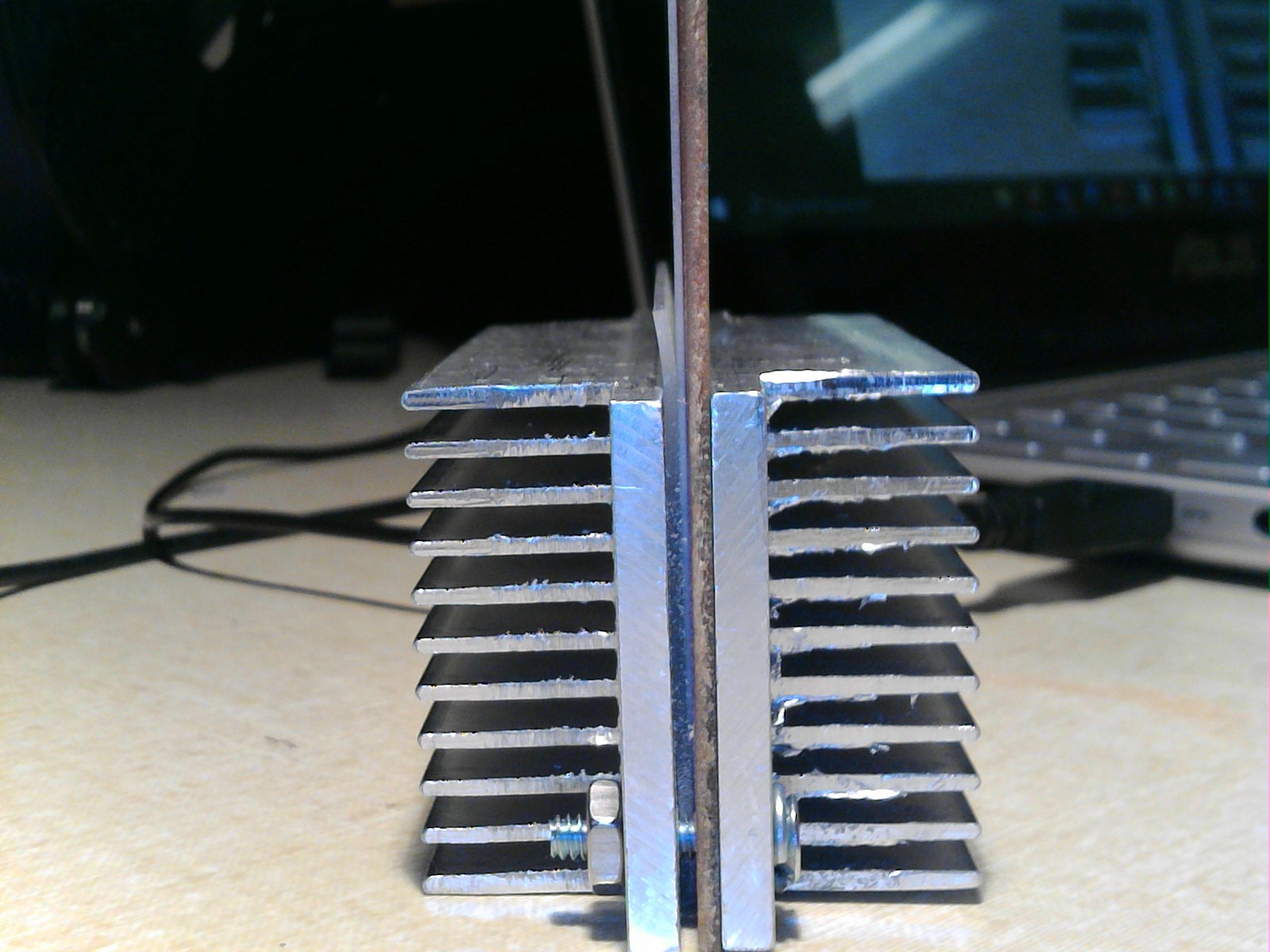 a view of the gen 1 print head assembly from the side. Both aluminum heat sinks are visible as are the various layers of the clamped assembly. the filament is at the bottom of this image, though too small to see.