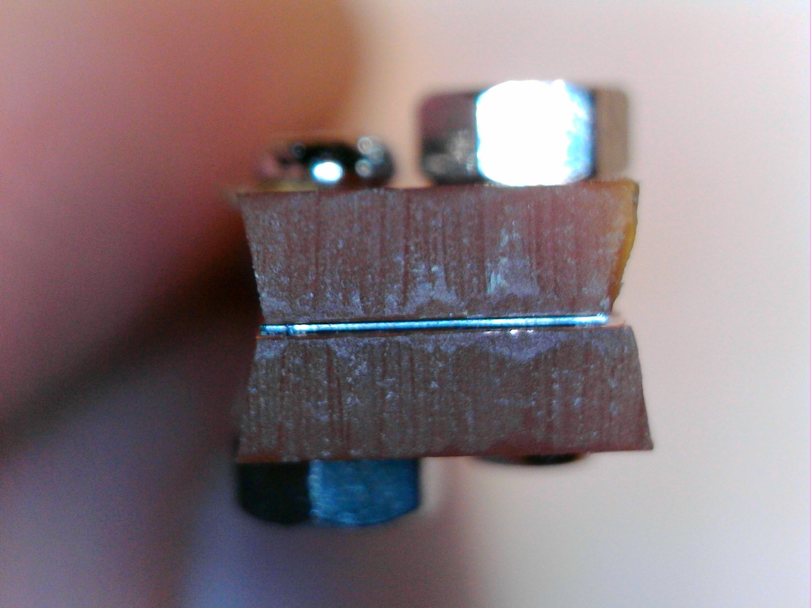 A view of the bottom of the gen 2 printhead. The "nozzle" is so thin on either side of the heating element as to be nearly invisible, even at this high level of magnification. It was ~30 microns tall, X 500 microns wide, thus why it is so hard to see! The heating element is visible center field, between the two orange-brown strip board pieces, as a narrow black/gray/white line.
