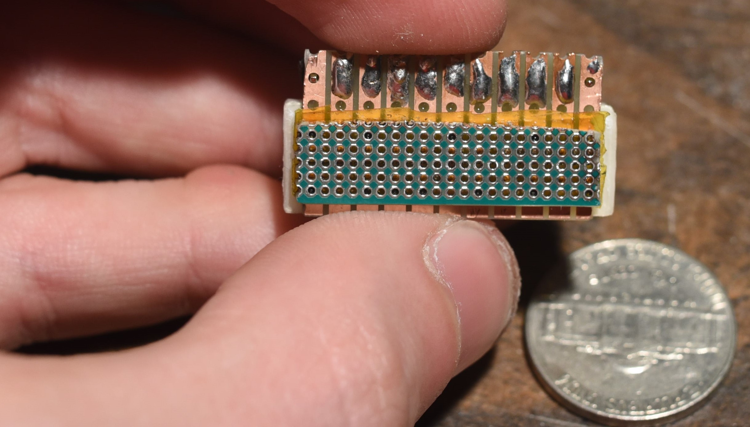 the generation 3 printhead, showing the 1.27mm pitch, 0.635mm diameter plated thru hole perfboard used as a nozzle plate, and the FR-4 strip board used as the connector plate.